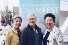 Three people at the CAAMFest 2018 Preview Screening standing in front of a CAAMFest banner and smiling.