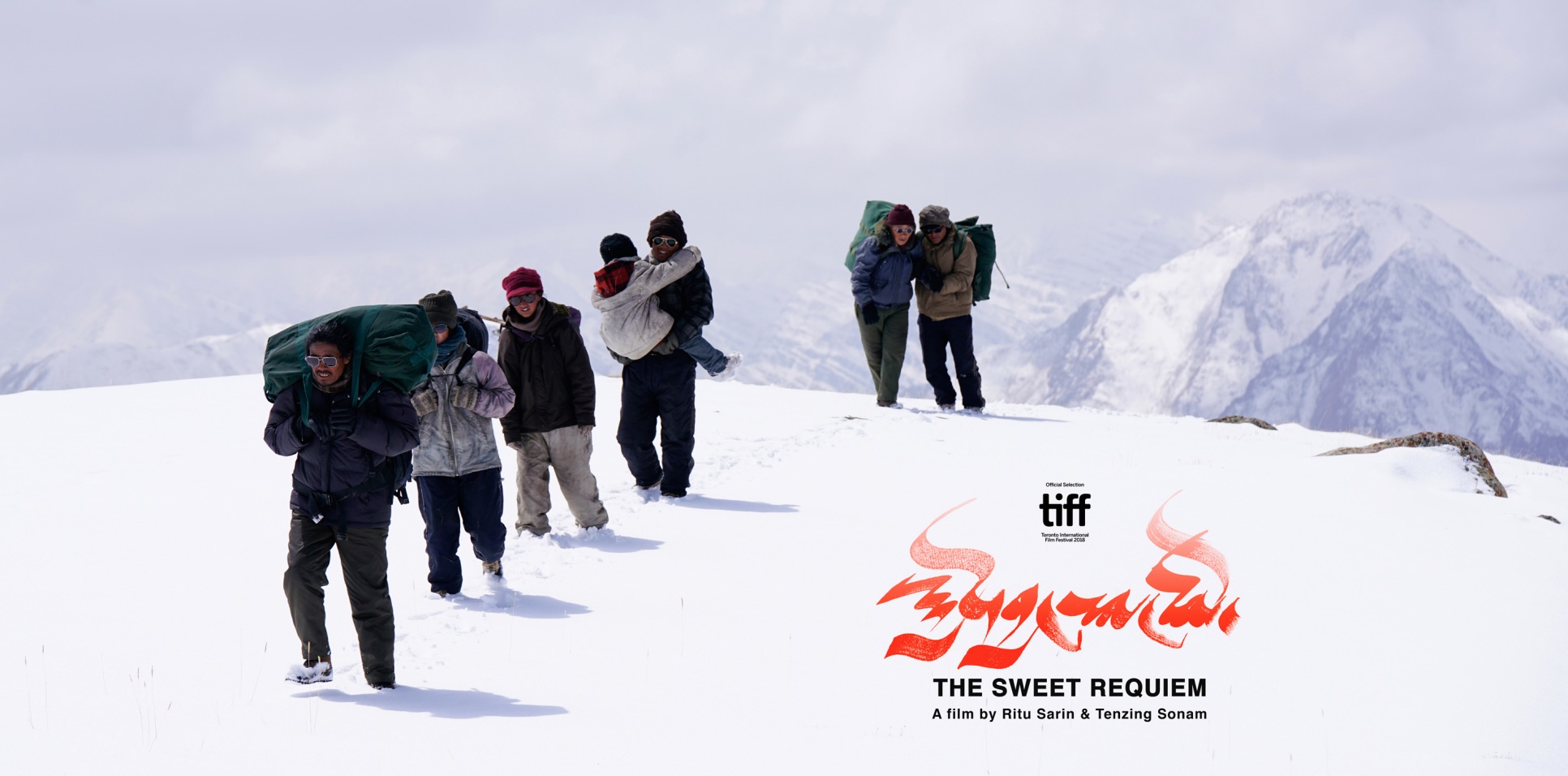 An image of people trekking through the snow filled Himalayan mountains.