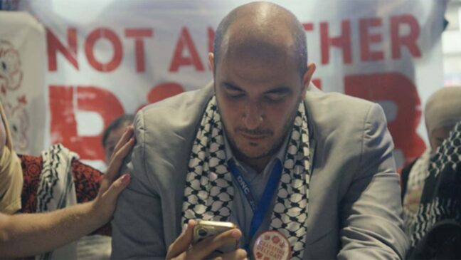 man looking at his phone wearing a suit
